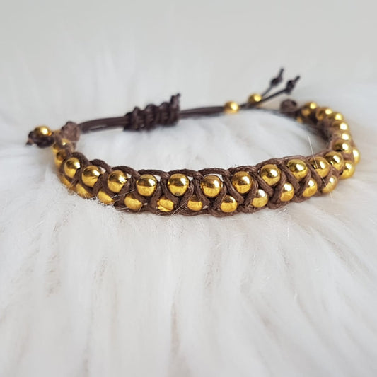 Knotted bracelet with gold-colored beads