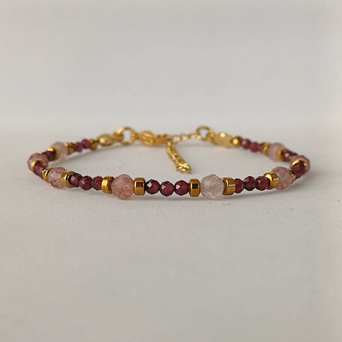 Armband met granaat en zonnesteen, afgewerkt met goudkleurige RVS kralen en sluiting – handgemaakt en vol warme tinten.