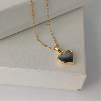 Goudkleurige RVS ketting met hartvormige hanger van zwartgrijs parelmoer met kleur overloop – elegant dames sieraad.