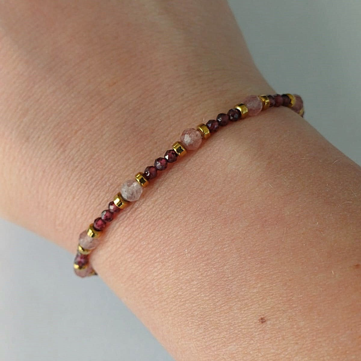 Armband met granaat en zonnesteen, afgewerkt met goudkleurige RVS kralen en sluiting – handgemaakt en vol warme tinten.