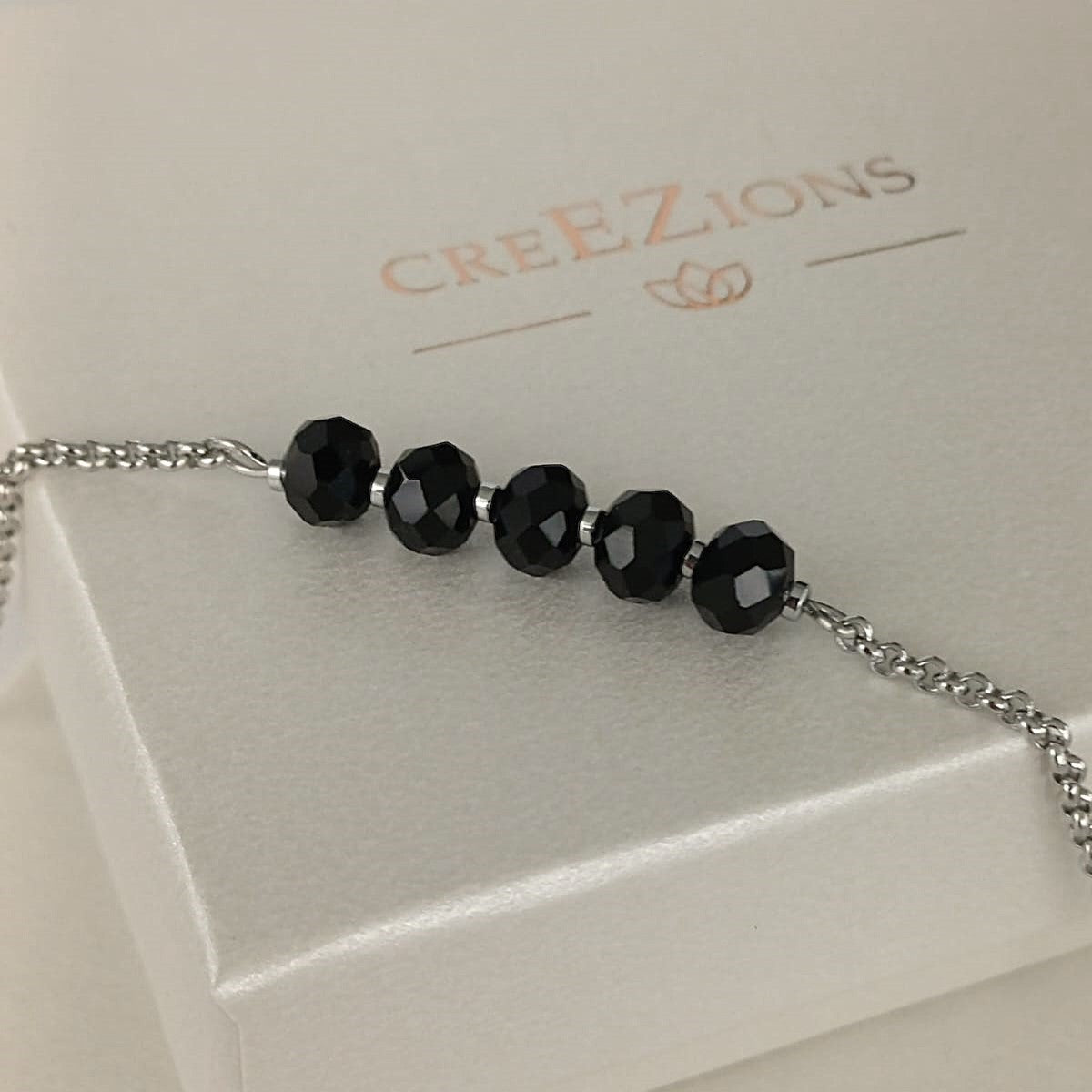 Goudkleurige RVS armband met zwarte facetkralen – tijdloze en minimalistische armband, ook verkrijgbaar in zilverkleur.