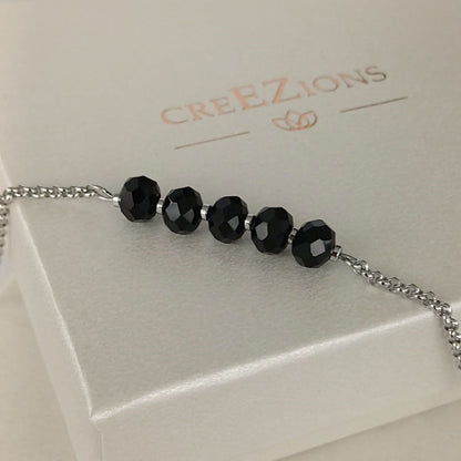 Goudkleurige RVS armband met zwarte facetkralen – tijdloze en minimalistische armband, ook verkrijgbaar in zilverkleur.