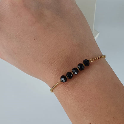 Goudkleurige RVS armband met zwarte facetkralen – tijdloze en minimalistische armband, ook verkrijgbaar in zilverkleur.