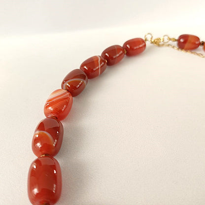 Kralenketting met rode agaat - warme roodtinten en goudkleurige details