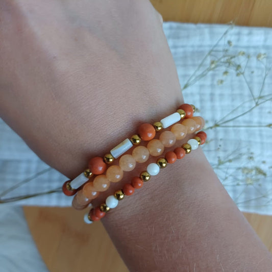 Set van armbanden in oranjeroze, wit en rood